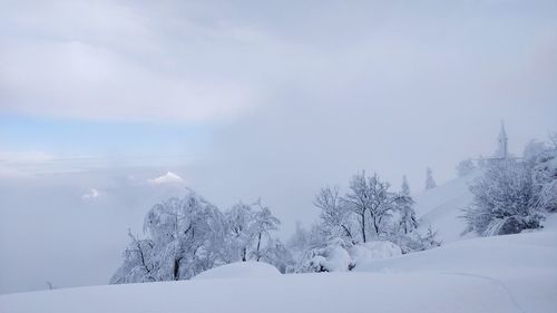 Snow covered landscape against sky