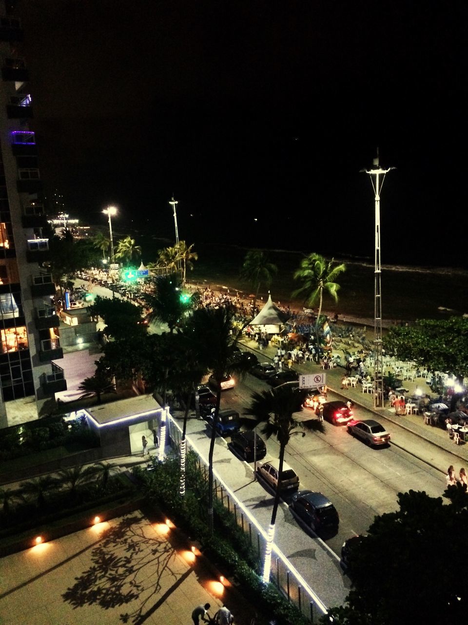 illuminated, night, street light, building exterior, city, architecture, built structure, street, lighting equipment, transportation, high angle view, road, city life, car, city street, mode of transport, sky, tree, land vehicle, outdoors