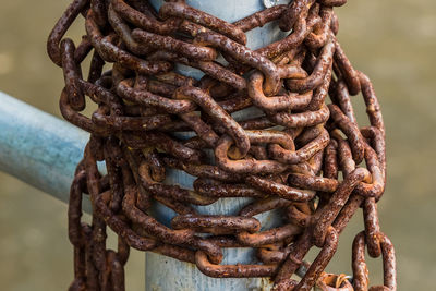 Close-up of rusty metal tied up on rope