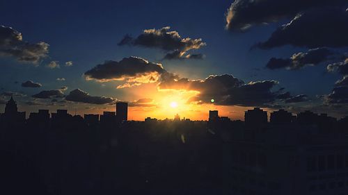 Silhouette city against sky during sunset