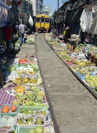 Train on railroad track amidst market stalls