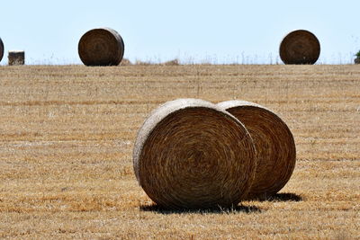 Hay bales on field against sky