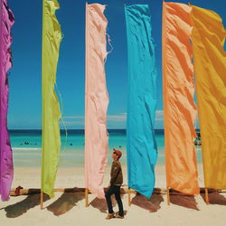 People standing at beach against blue sky