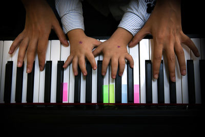 Cropped hand of kid playing piano