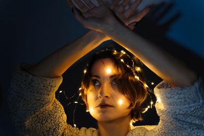 Portrait of a woman in the dark with string lights