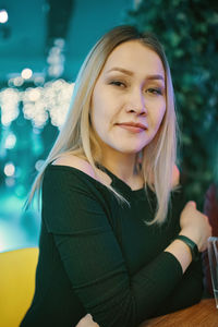 Portrait of a smiling young woman sitting outdoors