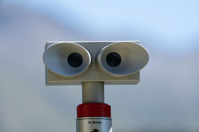Low angle view of coin-operated binoculars against sky