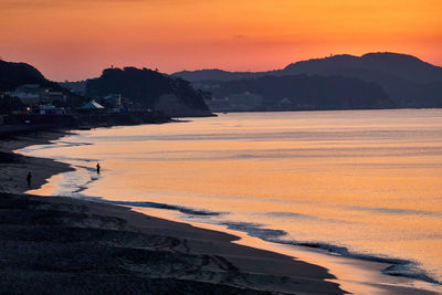 Scenic view of sea against orange sky during sunrise