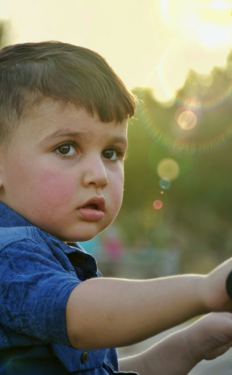 childhood, real people, one person, boys, innocence, cute, elementary age, outdoors, headshot, day, lifestyles, close-up, looking at camera, portrait