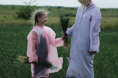 Daughter and mother standing on field