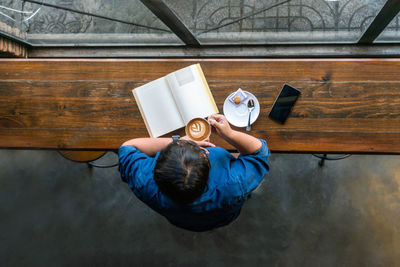 High angle view of man using mobile phone on table