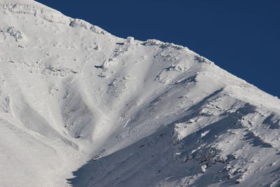 Scenic view of snowcapped mountains against clear blue sky