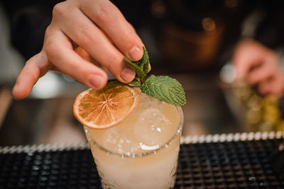 Close-up of hand holding drink on table