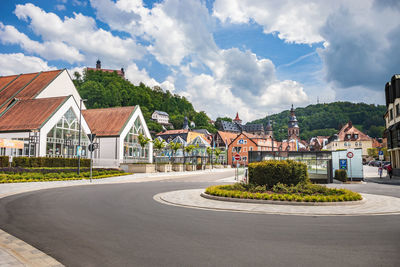 Houses by street and buildings against sky