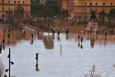 People on lake in city