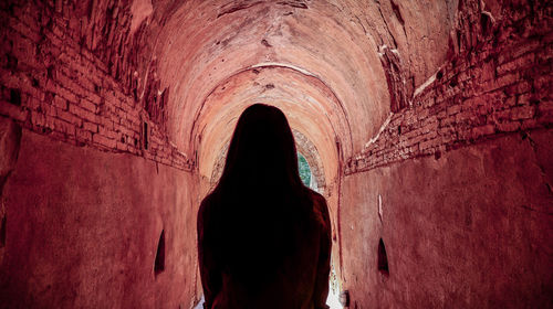 Rear view of man standing in tunnel