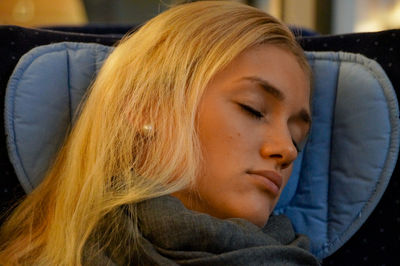 Young woman sleeping while traveling in train