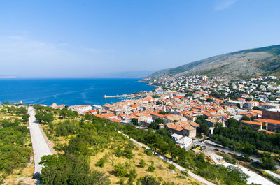 High angle view of town by sea against clear sky