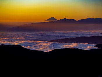 Scenic view of silhouette mountains against romantic sky at sunset