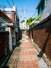 Footpath amidst buildings against sky