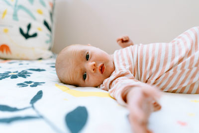 Closeup portrait of a baby girl laying on a colorful comforter