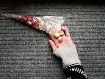 High angle view of hand by candies on rug