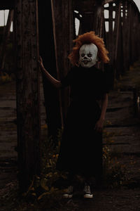 Young woman with mask standing in bridge