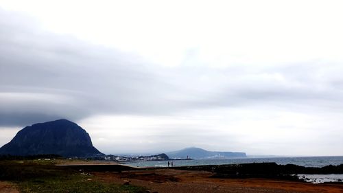 Scenic view of sea and mountains against sky
