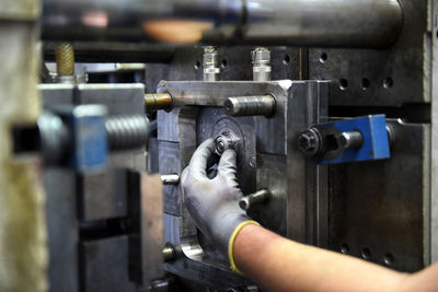 Person hand holding machine equipment in factory