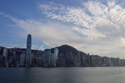 Sea by buildings against sky in city