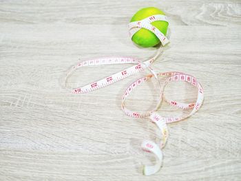 High angle view of tape measure by fruit on table