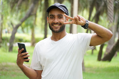 Young man using mobile phone while standing outdoors