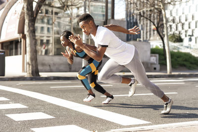 Man and woman practicing for sports race while running in city