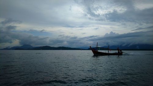 Boat in sea against sky during sunset