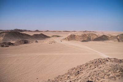 Scenic view of desert against clear blue sky