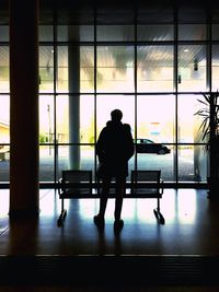 Rear view of silhouette man standing in airport building