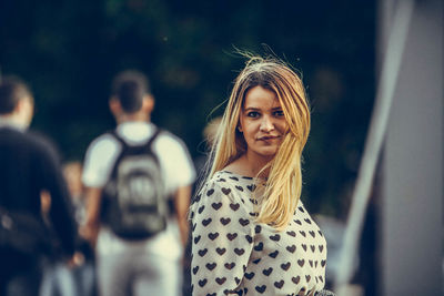 Portrait of smiling young woman standing on street