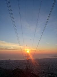 Electricity pylon against sky during sunset