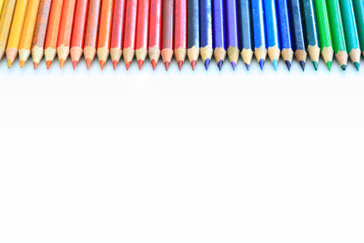 Multi colored pencils against white background