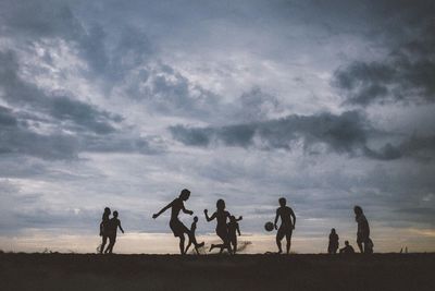 Silhouette of woman against cloudy sky