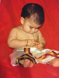 High angle view of cute boy holding red hat