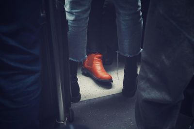 Low section of man wearing shoe sitting in train