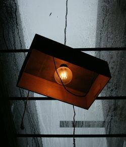 High angle view of illuminated light bulb hanging on wall