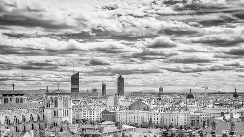 View of cityscape against cloudy sky