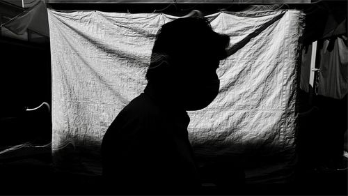 Rear view of woman looking through window