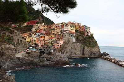 Scenic view of coast by buildings against sky...