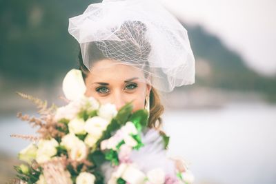 Portrait of woman with pink flowers against blurred background