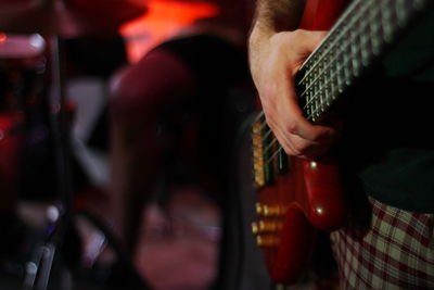 Midsection of man playing guitar