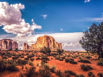 Rock formations on landscape against cloudy sky