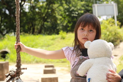 Portrait of girl with toy against trees